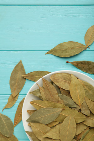 Bay leaves in bawl on blue background. vertical photo. top viewの写真素材