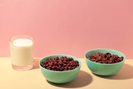 Set of various breakfast cereals with glass of milk on pink background. top viewの写真素材