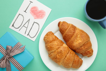 Father's day concept with gift, card and breakfast. Breakfast for dad with croissant and coffee. I love dadの写真素材