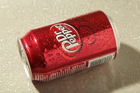 Mykolaiv, Ukraine - May 2, 2023: Can of Dr. Pepper on gray background, with water drops. top view