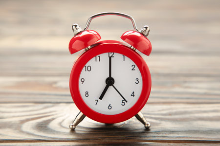 Red vintage alarm clock on brown background. Space for text. top view
