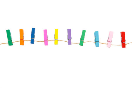 Colored wooden clothespins on a rope isolated on white background. design elements. macro. top view