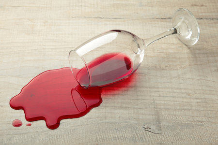 Glass of red wine fell on laminate, wine spilled on floor. Top viewの写真素材