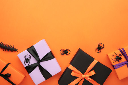 Happy Halloween holiday concept. Flat lay gift boxes, orange pumpkins, bats, spiders on orange background. Halloween greeting card template. Top viewの写真素材