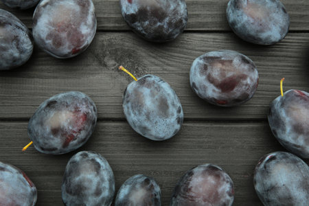 Ripe plums on black wooden background. The autumn harvest. Top viewの写真素材