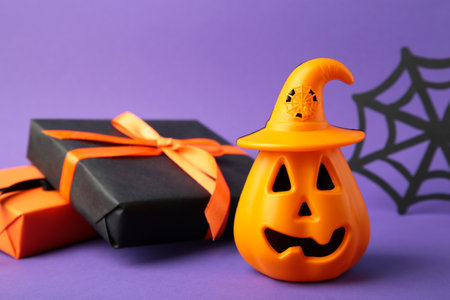 Composition with gift boxes and pumpkin for Halloween on violet background. top viewの写真素材