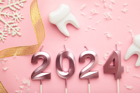 Figure 2024 and tooth with Christmas decoration on pink background. Top viewの写真素材