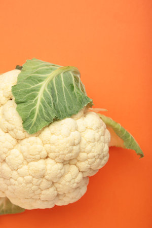 Fresh organic cauliflower on orange background. Vertical photo. Top viewの写真素材