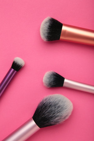 Professional female cosmetics brushes for makeup and eyelash brush on pink background. Cosmetics...