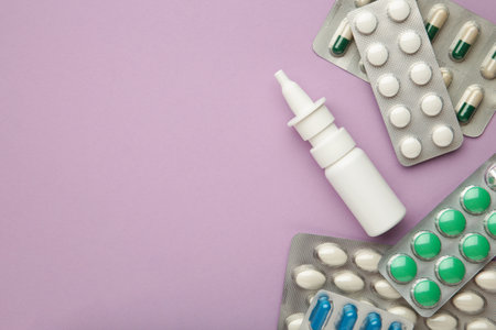 Nasal spray with pills on purple background. Medicine