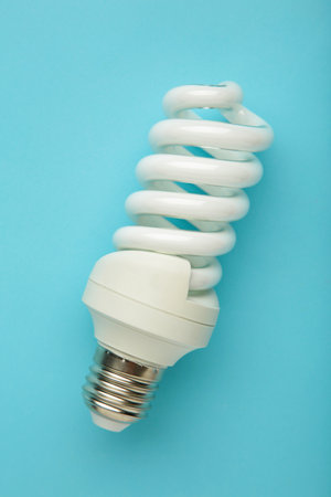 Light bulb on blue background. Space for text. Top view