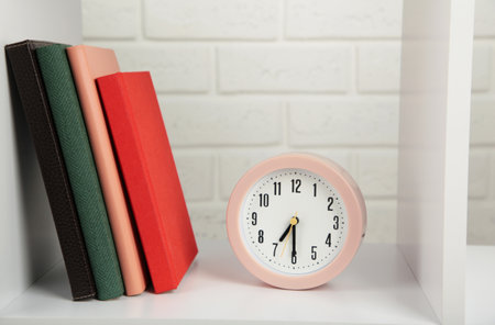 Notebooks and pink clock on a light background. Top viewの写真素材