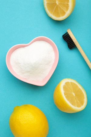 Toothbrush with lemon and baking soda on blue background. Vertical photo. Top viewの写真素材
