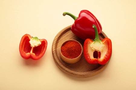 Paprika powder with fresh red pepper on beige background. Top view