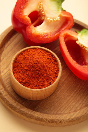 Paprika powder with fresh red pepper on beige background. Vertical photo. Top view