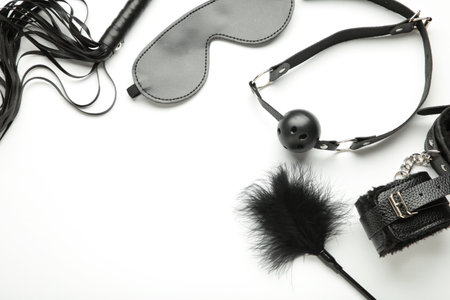 Set of erotic toys for BDSM on white background. The game of sexual slavery with a whip, gag and leather blindfold. Intimate sex games. Top viewの写真素材