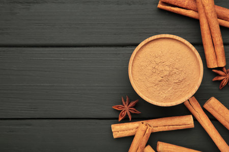Cinnamon sticks on black wooden background. Cinnamon spice in bowl. Ceylon cinnamon.