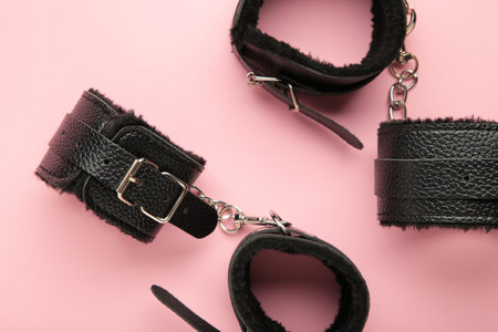Handcuffs for sex games on pink background. Sexy bdsm toy. Fetish, erotic concept.の写真素材