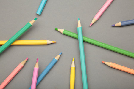 Pastel color pencils on gray background. Top view