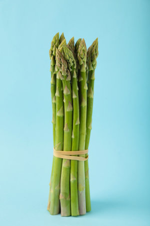 Fresh green asparagus or bunches of green asparagus on blue background. Top viewの写真素材