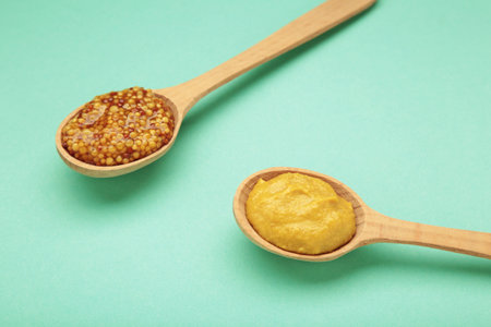 Different mustard in spoon on mint background with clipping path. Top viewの写真素材