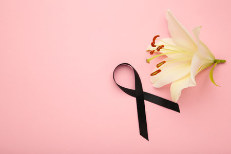 White liles flowers with black ribbon. Mourning or funeral backgroundの写真素材