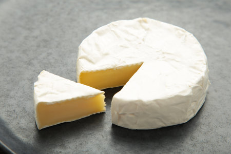 Slice camembert cheese on dark background. Top view