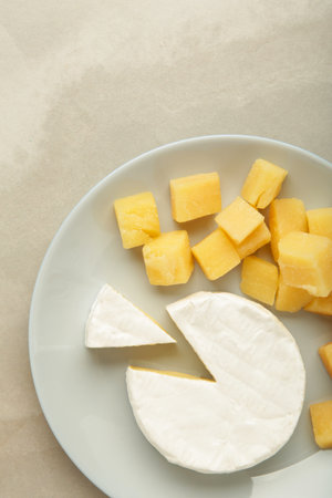 Parmesan cheese with camembert on plate on light background. Top viewの写真素材