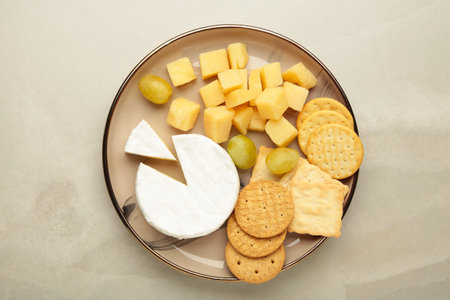 Cheese platter with different cheese and crackers on plate on light background.の写真素材