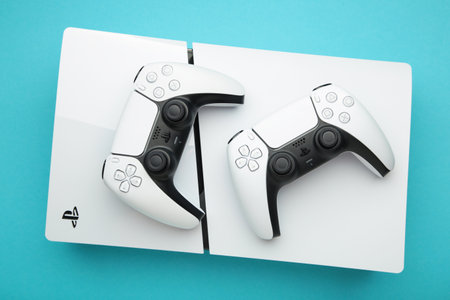 Mykolaiv, UKRAINE - July, 2024: White console PlayStation 5 and gamepad on blue background