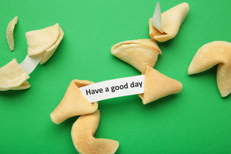 Fortune cookie with text saying 'Have a good day' on green background. top viewの写真素材