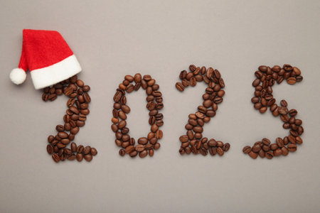 The inscription number 2025 laid out from coffee beans with Santa Claus hat.の写真素材