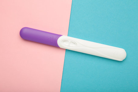 The new pregnancy test on pink and blue background. Health care concept. Top view