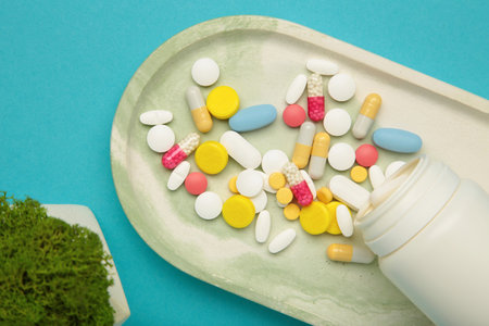 Assorted pharmaceutical medicine pills, tablets and capsules and bottle on blue background. Top viewの写真素材
