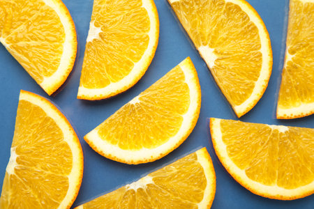 Colorful orange citrus fruit slices background on blue. Top view