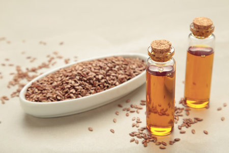 Flaxseeds with flaxseed oil in glass bottle on light background. Top viewの写真素材