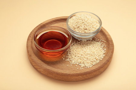 Sesame seeds and sesame oil on beige background. Top view