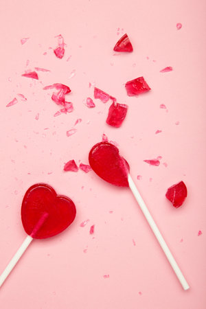 Broken heart lollipop on pink background. Top viewの写真素材