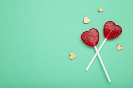 Sweet heart shaped lollipops on mint background. Valentine's day celebration.の写真素材
