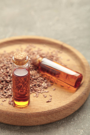 Flaxseeds with flaxseed oil in glass bottle on gray concrete background. Top viewの写真素材