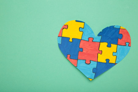 World Autism Awareness day, mental health care concept with puzzle on heart on mint background.の写真素材