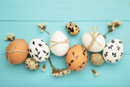 Composition with Easter eggs on blue wooden background. Space for text