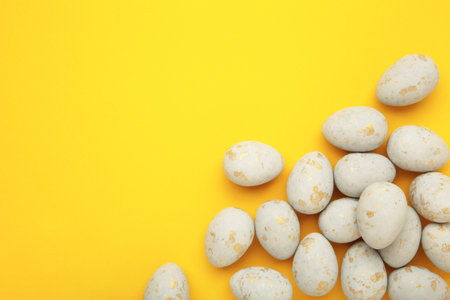 Easter eggs in a speck on yellow background. Easter holiday composition Top view