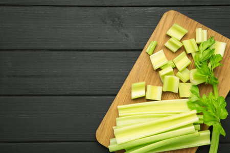 Fresh green cut celery on black wooden background. Top viewの写真素材