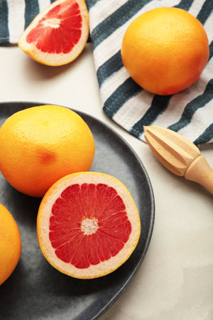 Fresh Organic grapefruit and a wooden juicer on light backgroundの写真素材