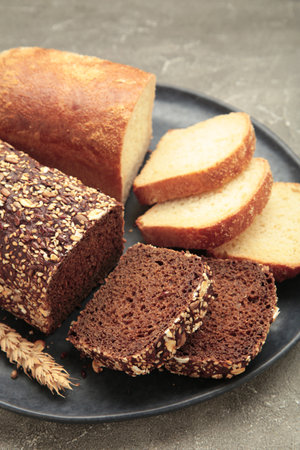Different bread on plate on gray background. Top view