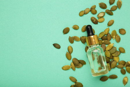 Pumpkin seed oil on mint background. Space for textの写真素材