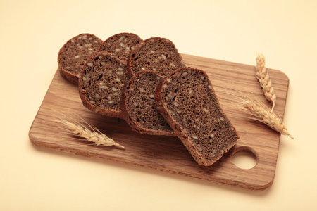 Slice of wholemeal dark bread on beige background. Top view