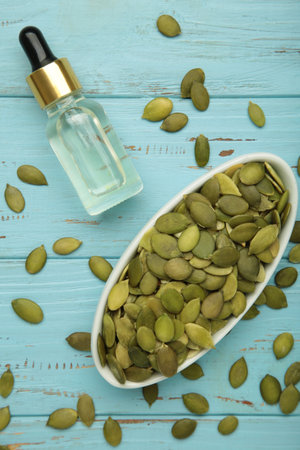 Pumpkin seed oil on blue wooden background. Vertical photoの写真素材