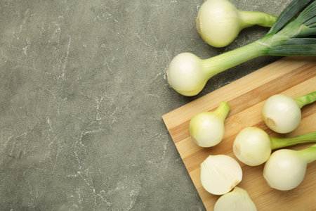 Green onion on cutting board on gray concrete background. Top viewの写真素材